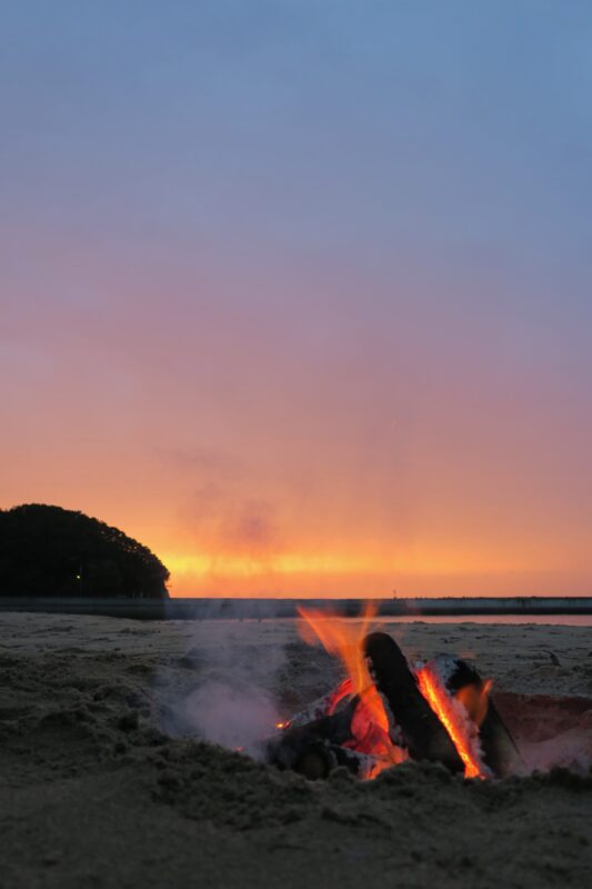 夜のキャンプで焚き火が静かに燃えている様子